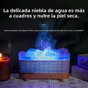 Humificador ultrasónico de madera con luz LED azul y niebla aromática, sobre superficie textil con velas encendidas al fondo.