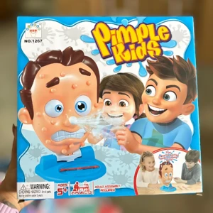 Caja del juego Pimple Kids con de cabeza gigante con espinillas y dos niños interactuando con el tablero azul.