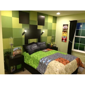 Lámpara de mesa con base metálica y pantalla transparente, sobre mesita de noche en habitación decorada con temática Minecraft.