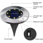 Luz de piso solar con panel fotovoltaico, LEDs y cubierta impermeable, montada sobre estaca metálica para instalación en exteriores.