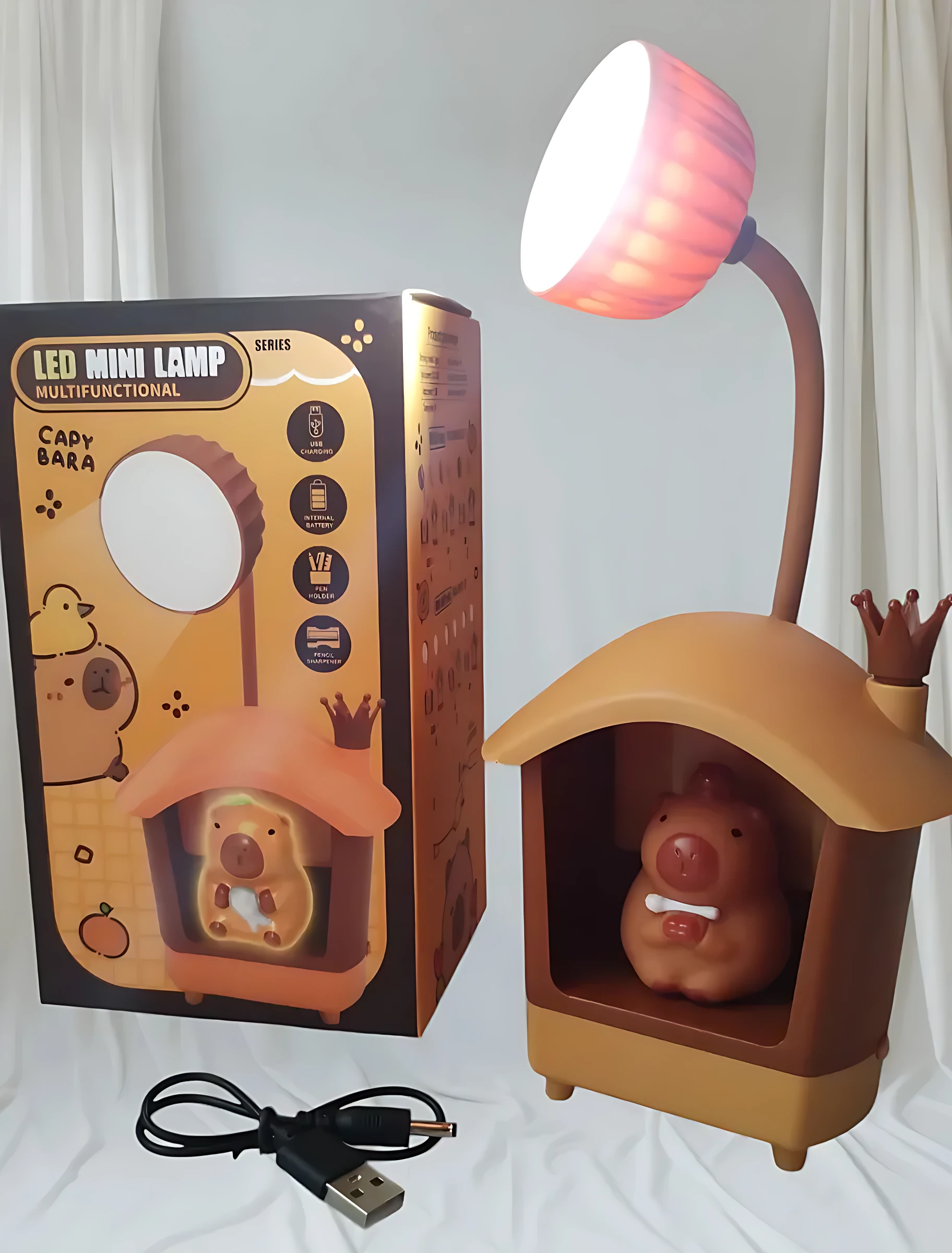 Lámpara LED multifuncional en forma de casa con capybara, incluye sacapuntas y porta lápices, con cable USB incluido.