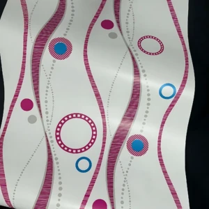 Papel adhesivo decorativo con diseño geométrico en líneas onduladas rosas y círculos azules sobre fondo blanco, ideal para renovar paredes sin obras.