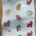 Papel adhesivo decorativo infantil con personajes de My Little Pony sobre fondo azul claro con patrones de nubes.