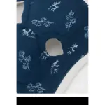 Parche de rodilla acolchado en color azul marino con estampado floral blanco, mostrando la abertura central para ajuste y textura suave de la tela.