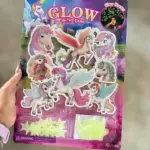 Pack de pegatinas con unicornios fluorescentes en colores rosa, blanco y azul, con alas y cuernos brillantes; incluye estrellas y luna en resina luminosa para decorar habitación infantil.