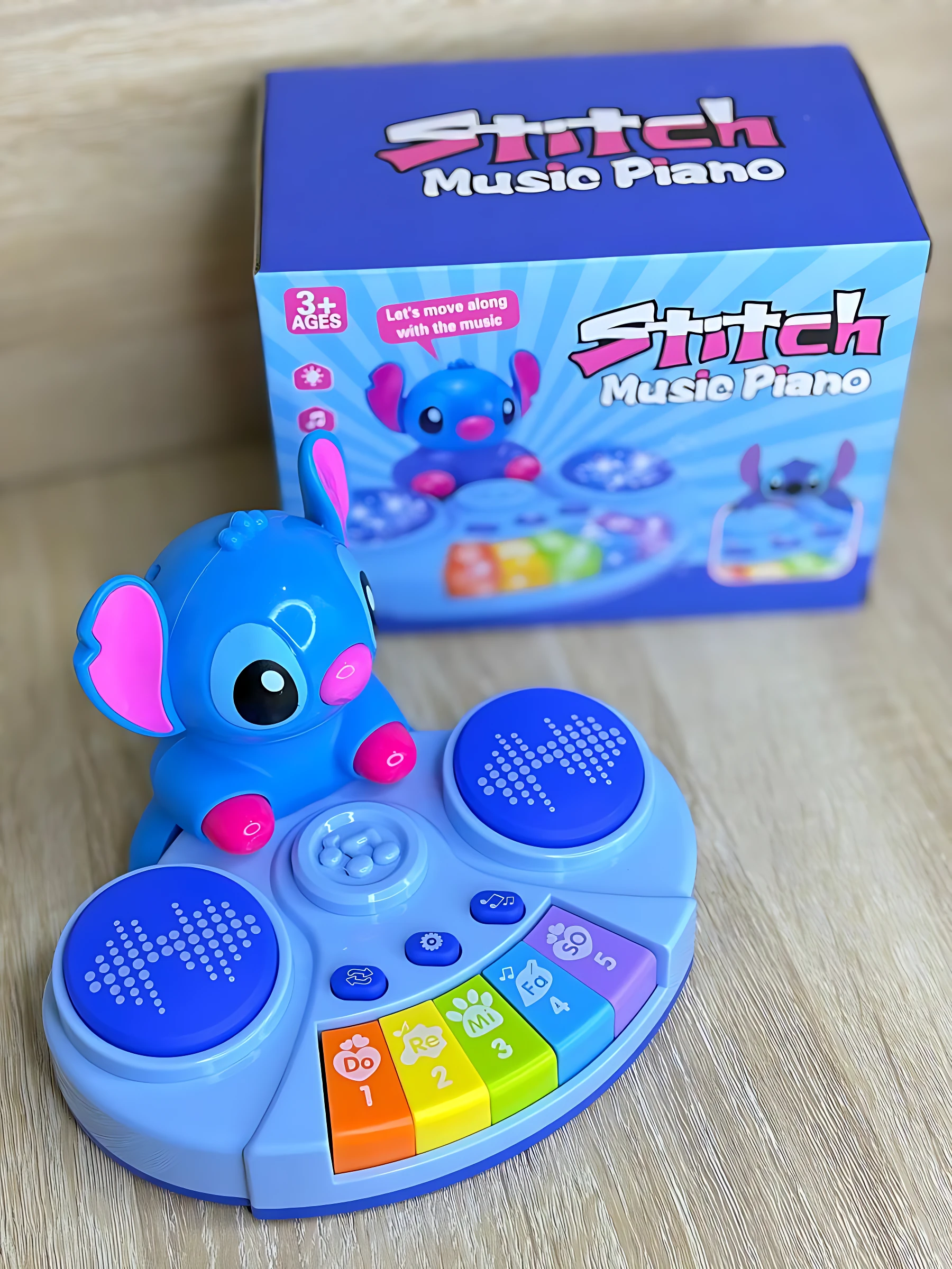 Piano musical Stitch azul con teclas de colores y botones, acompañado de su caja original. Ideal para niños mayores de 3 años.