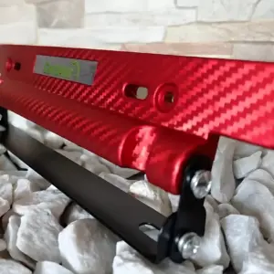 Porta placa fibra carbono rojo con platina metálica, diseñado para proteger matrícula y elevar estilo deportivo del vehículo.