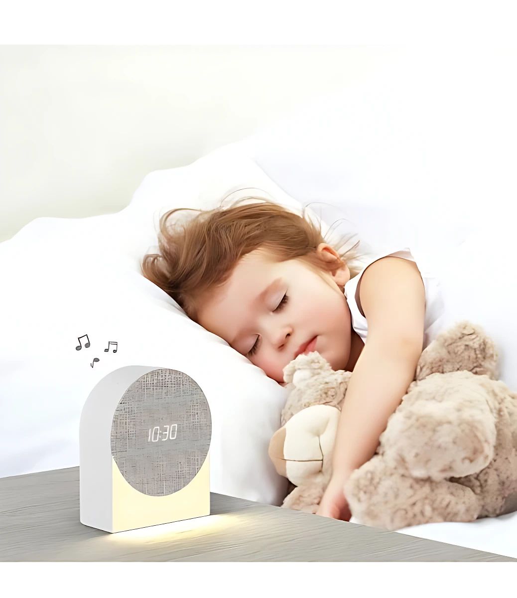 Reloj despertador inteligente blanco con pantalla digital mostrando 10:30, emitiendo luz nocturna suave sobre mesa de noche, acompañado de niña durmiendo abrazando peluche.