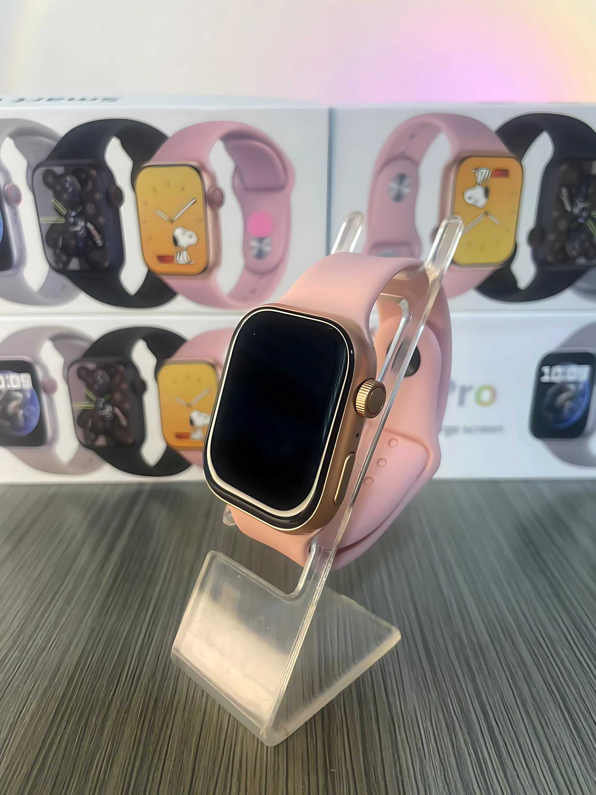 Reloj inteligente S9 Pro en color rosa con correa de silicona, exhibido sobre soporte transparente. Caja de presentación al fondo.