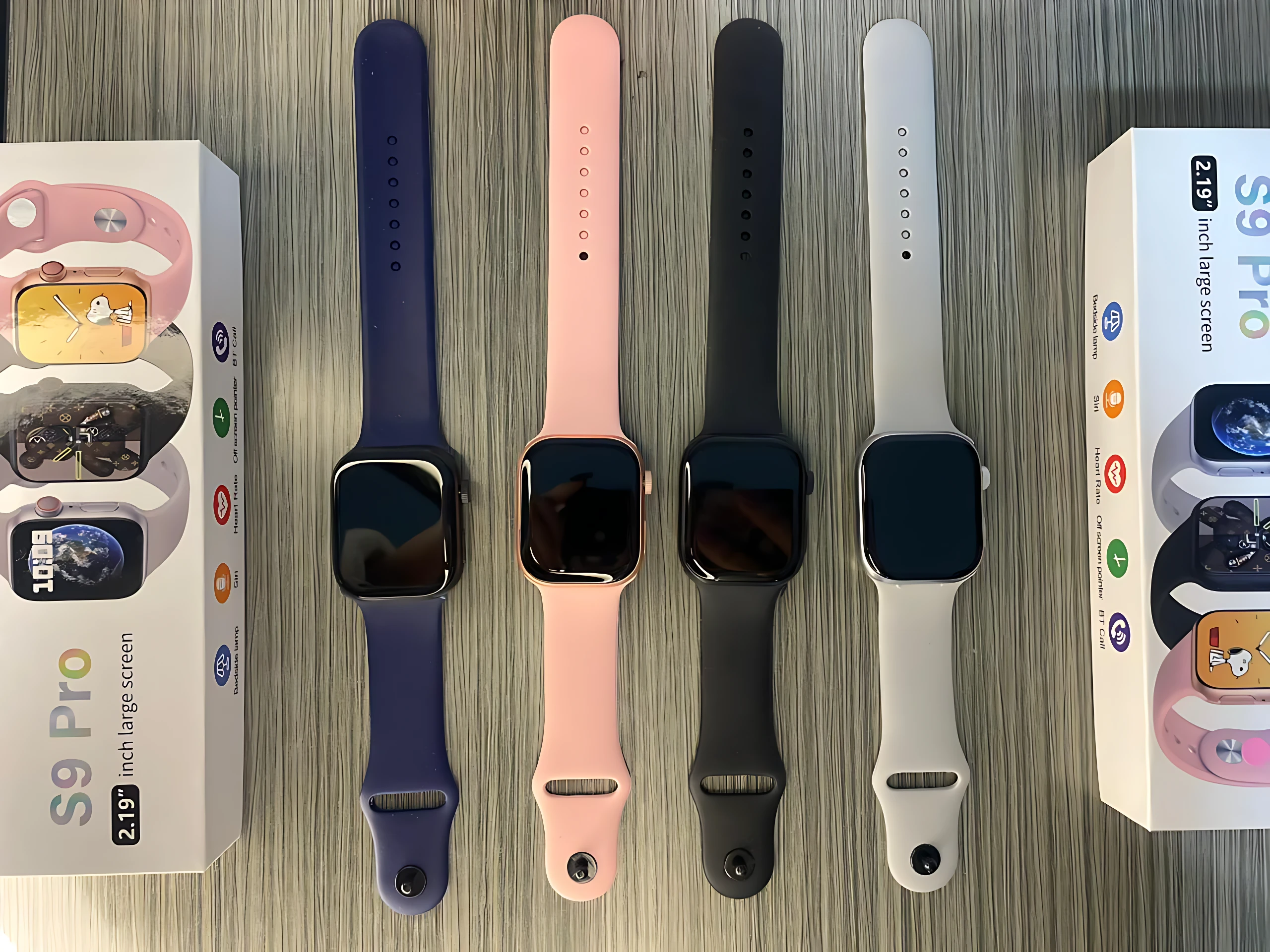 Cuatro relojes inteligentes S9 Pro con correas en azul, rosa, negro y blanco, mostrados junto a sus cajas de presentación.