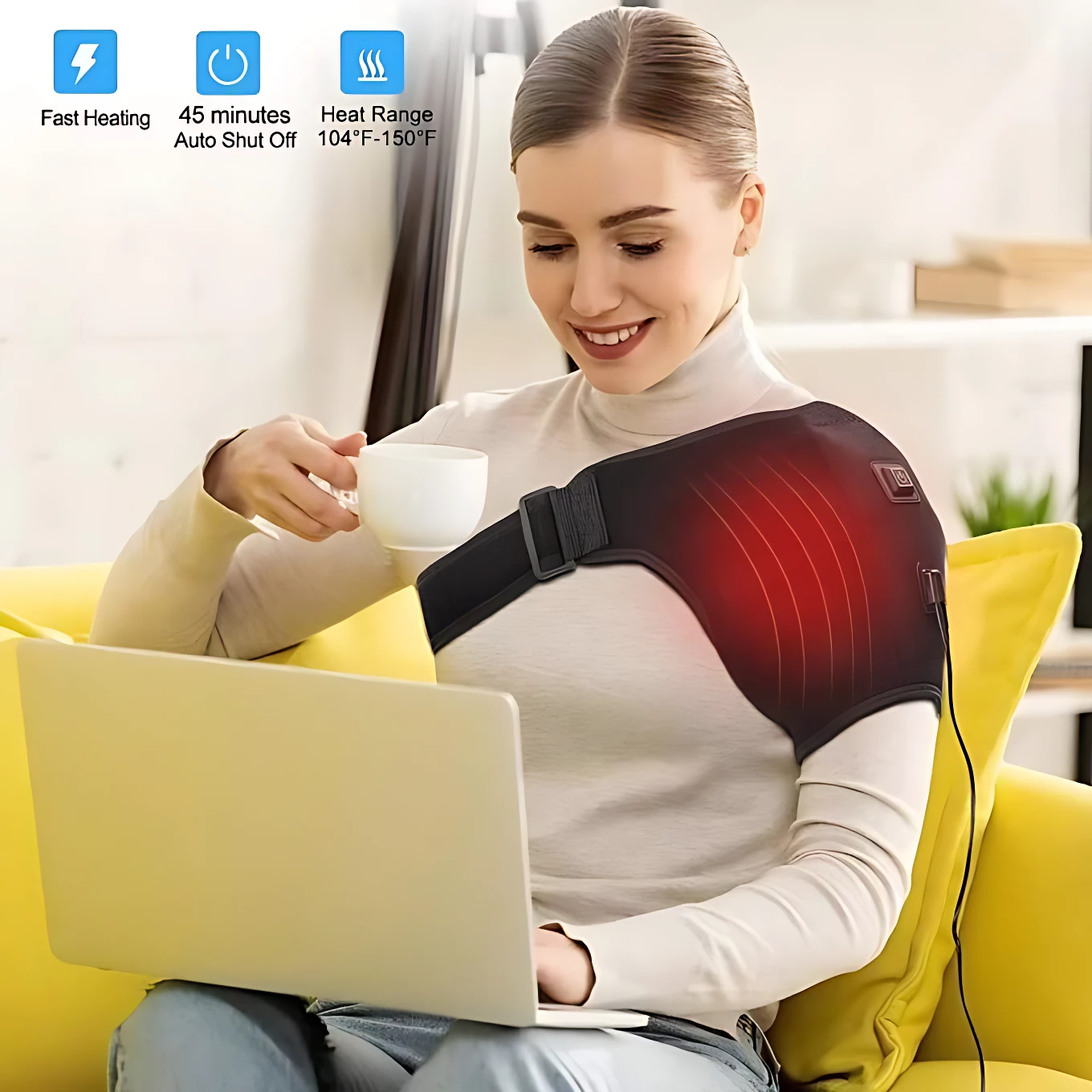 Mujer usando soporte de hombro térmico negro con zona roja de calor, sentado en sofá amarillo mientras usa laptop y sostiene taza blanca.