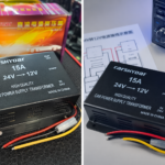 Convertidor negro de voltaje de 24V a 12V 15A con su caja, manual y radio instalado sobre una superficie.