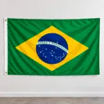 Bandera de Brasil de poliéster 150x90 cm con ojales metálicos, colgada en una pared blanca para exterior y eventos deportivos.