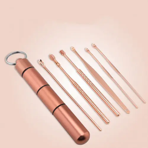 Kit de limpieza de oídos color oro rosa con estuche cilíndrico portátil y seis herramientas metálicas de diversas puntas y formas.