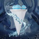 Filtro atrapa motas blanco con forma de cono y esferas azules, flotando en agua agitada dentro del tambor de una lavadora.