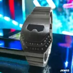 Reloj inteligente de metal gris con acabado cepillado, números LED en el borde y diseño futurista, sobre fondo de luces neón azul y rojo.