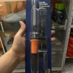 Mano sosteniendo cautín tipo lápiz de 60W con mango naranja y negro, empacado en blíster azul de la marca Mercury.