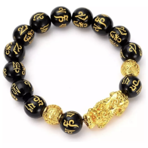 Pulsera de cuentas de obsidiana negra con grabados dorados, dije de Pi Xiu y cuenta ornamental dorada sobre fondo blanco.