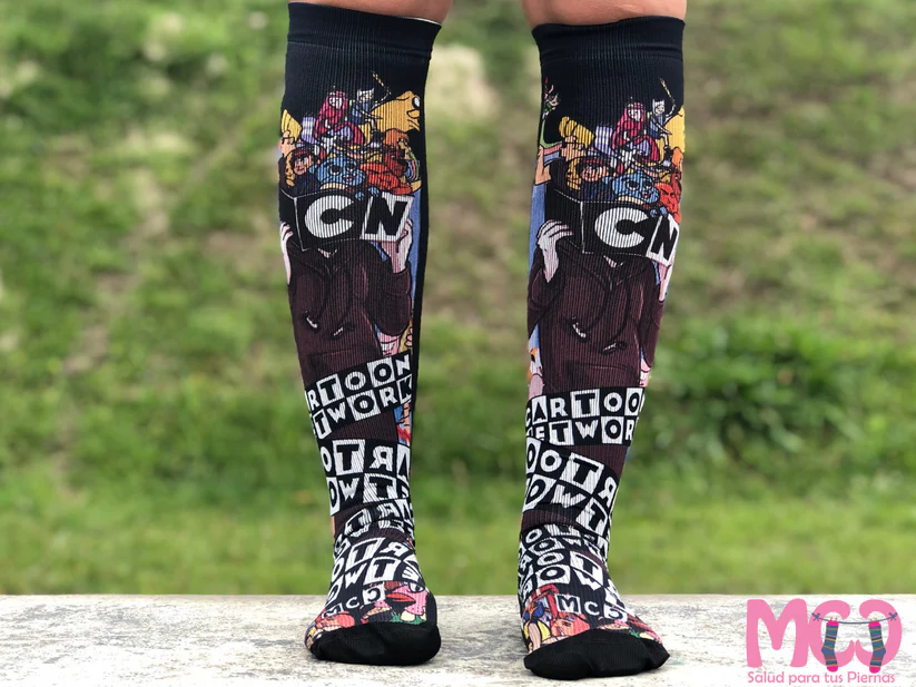 Medias de compresión altas negras con diseño estampado de personajes de Cartoon Network, usadas para estimular la circulación en las piernas.