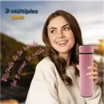 Termo inteligente rosa con pantalla LED táctil y tapa negra, sostenido por una mujer sonriente al aire libre.