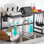 Escurridor de platos metálico negro sobre lavaplatos doble, con platos, tazones, cuchillos y utensilios, optimizando el espacio de secado.
