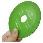 Disco diamantado verde circular para vidrio, jade y cristal, con textura abrasiva, sostenido por una mano para mostrar su escala.