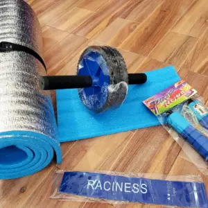 Kit de entrenamiento con colchoneta plateada y azul, rueda abdominal, colchoneta azul plana y bandas de resistencia sobre piso de madera.