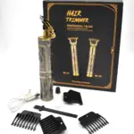 Kit de patillera profesional dorada con grabado, caja, cable USB, aceite, cepillo y cuatro peines guía negros sobre fondo blanco.