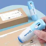 Corrector azul y blanco para papel térmico con abrecajas integrado, aplicado sobre etiqueta de envío para ocultar datos personales.