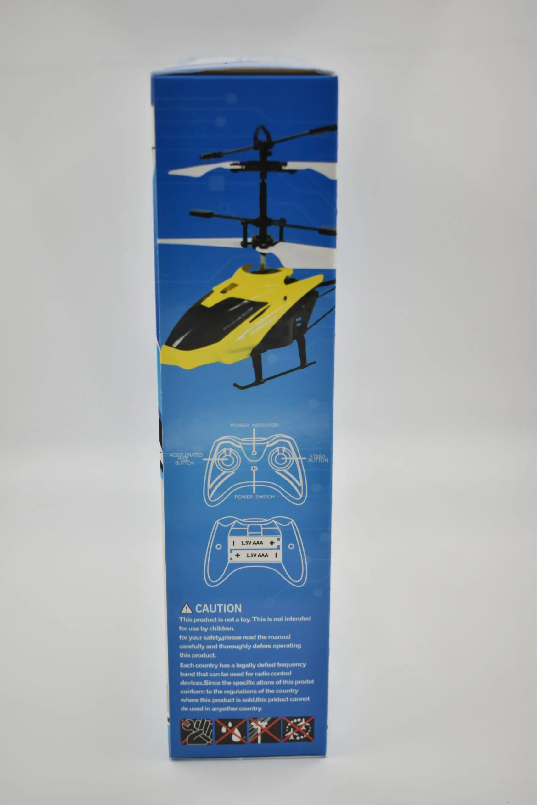 Empaque azul de helicóptero a control remoto amarillo y negro con doble rotor, diagramas del mando y advertencias de seguridad.
