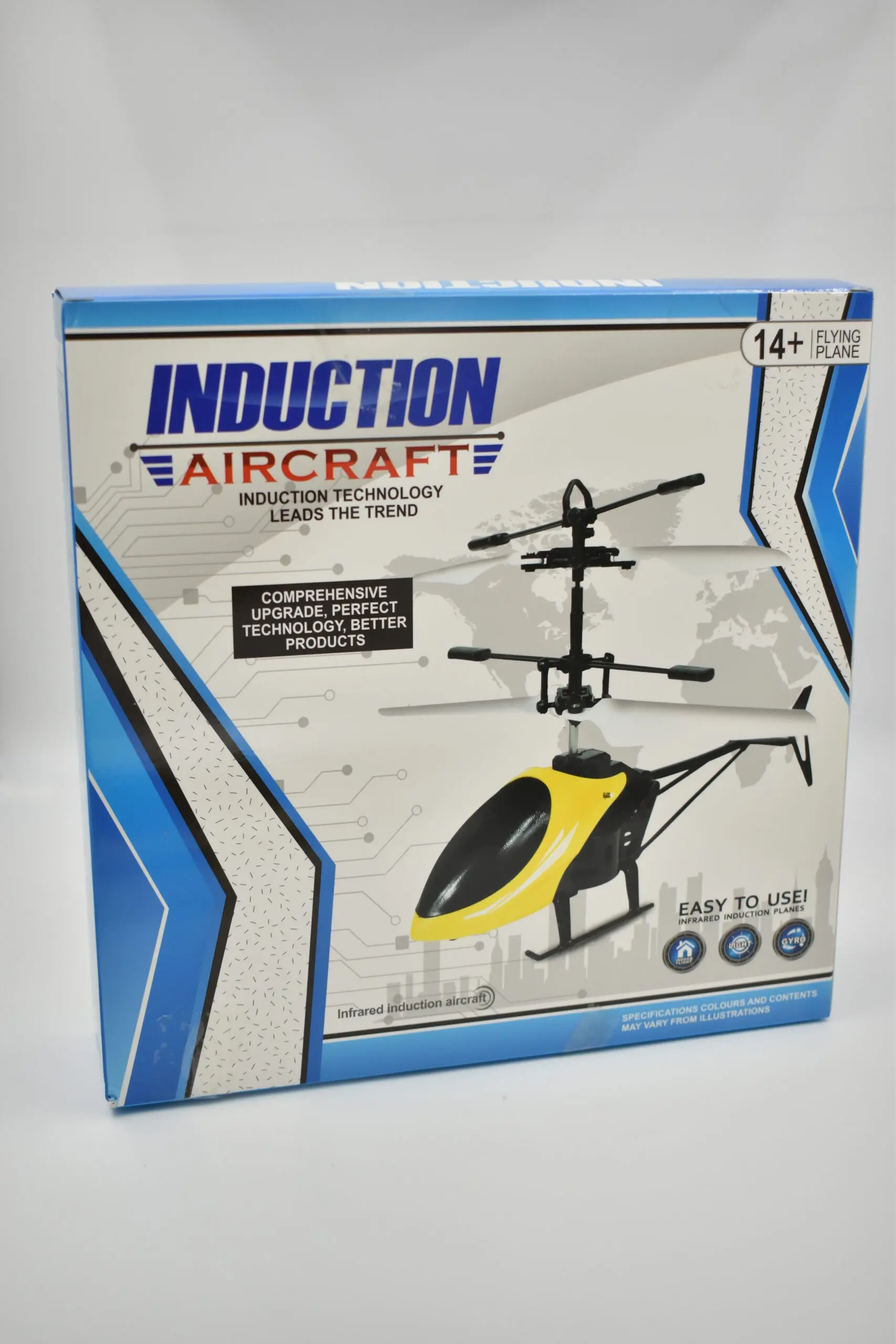 Helicóptero a control remoto amarillo y negro con doble rotor en caja de diseño tecnológico azul y blanco de Induction Aircraft.