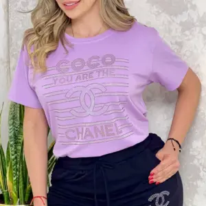 Conjunto casual de blusa lila con estampado y bermuda negra con cordón y logo lateral, ideal para uso diario.