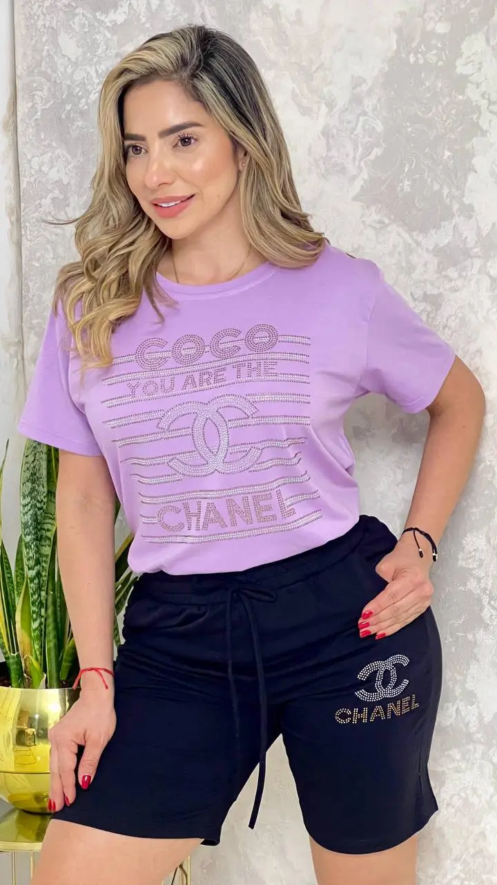Conjunto casual de blusa lila con estampado y bermuda negra con cordón y logo lateral, ideal para uso diario.