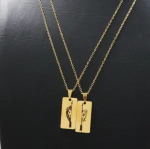 Collar de pareja de acero inoxidable dorado con dos dijes en placa rectangular con grabado de león y flecha.