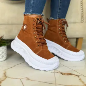 Bota media caña de gamuza café para mujer con suela blanca alta, cordones y detalle de estrella en el lateral.