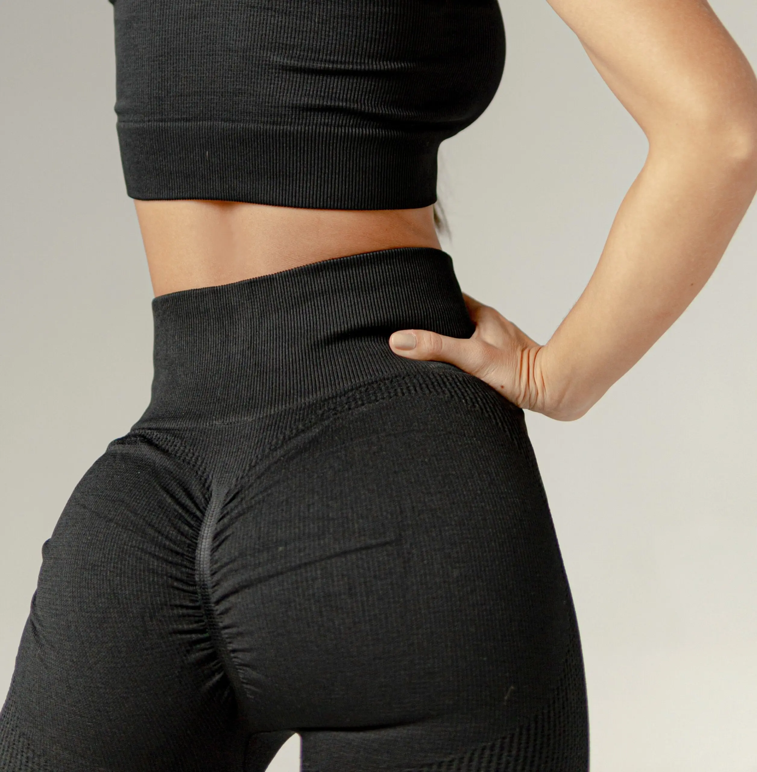 Leggins deportivos negros de pretina alta y diseño push up con realce, fabricados en tela texturizada sin costuras.