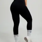 Leggins deportivos negros de pretina alta y diseño seamless con efecto push up, combinados con medias blancas y zapatillas.