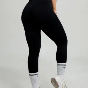 Leggins deportivos negros de pretina alta y diseño seamless con efecto push up, combinados con medias blancas y zapatillas.