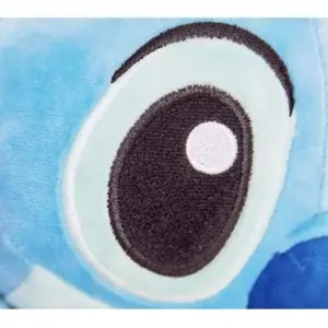 Detalle del ojo de peluche Stitch azul de textura suave, con iris celeste y pupila negra con un brillo blanco.