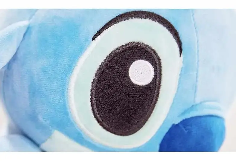 Detalle del ojo de peluche Stitch azul de textura suave, con iris celeste y pupila negra con un brillo blanco.
