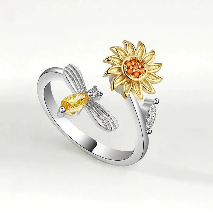 Anillo ajustable plateado y dorado con diseño abierto de girasol texturizado y abeja con cristales amarillos.
