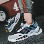 Zapatillas urbanas para hombre en negro, blanco y azul con suela gruesa ondulada y detalles texturizados, vistas en ángulo sobre asfalto.