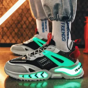 Zapatillas urbanas para hombre en color gris y negro, con luces neón verdes brillantes en la suela y lateral, diseño reflectivo y cordones grises.