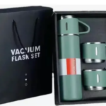 Set de termo de acero inoxidable verde mate con dos tazas en caja negra y bolsa de regalo. El termo tiene una banda blanca y roja.