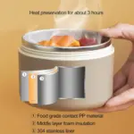 Lonchera térmica beige con corte transversal que muestra tres capas de aislamiento: PP, espuma y acero inoxidable 304, con comida caliente dentro.
