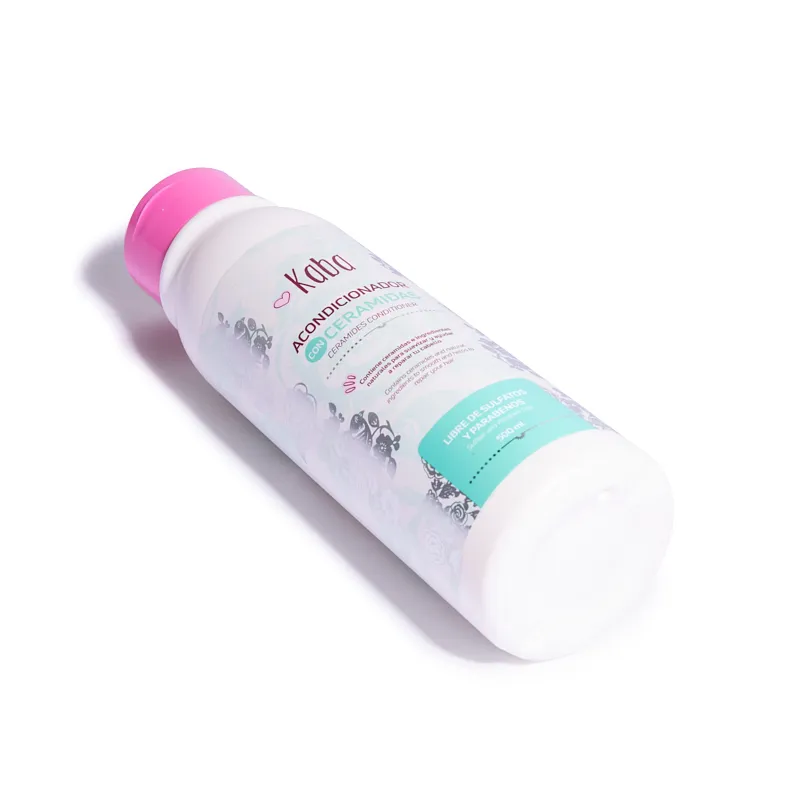 Botella cilíndrica de acondicionador Kaba de 500 ml con tapa fucsia, etiqueta blanca y turquesa con detalles florales grises y texto descriptivo.