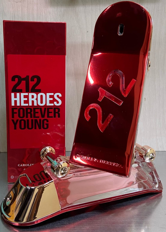 Frasco de perfume Carolina Herrera 212 Heroes rojo metálico con diseño de patineta junto a su caja roja con letras blancas.