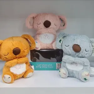 Tres peluches de koala en colores naranja, rosa y gris con función de música y respiración sobre fondo blanco.