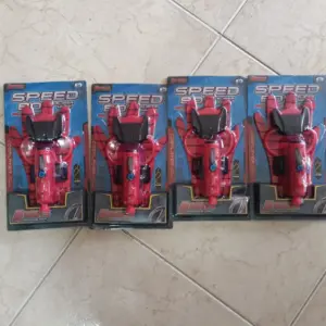 Cuatro guantes rojos lanzadores de agua para niños y cosplay de Spiderman en empaques originales sobre piso de cerámica.