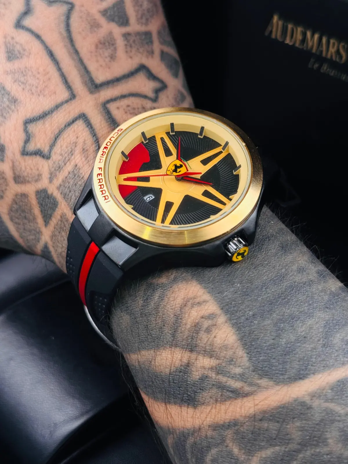 Reloj deportivo para hombre con correa de goma negra, caja dorada y esfera inspirada en rin de automóvil con detalles rojos.